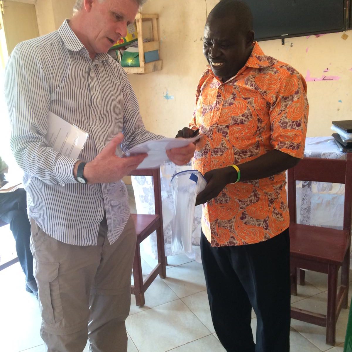 Peter handing microscope details to project director Francis Candiga